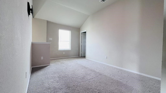 carpeted spare room featuring high vaulted ceiling