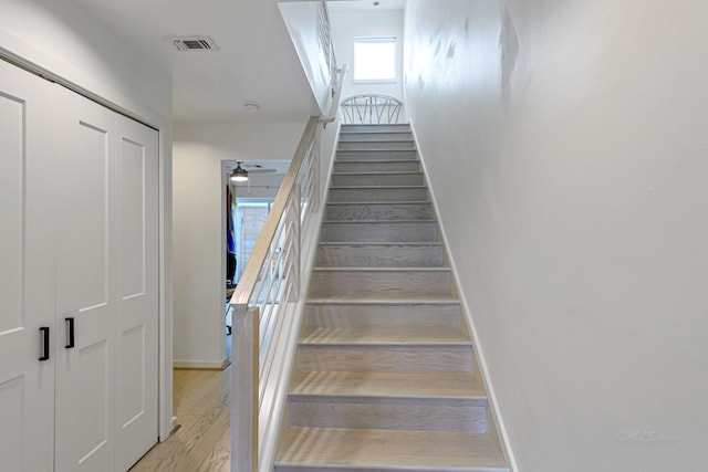 stairway featuring hardwood / wood-style flooring and ceiling fan