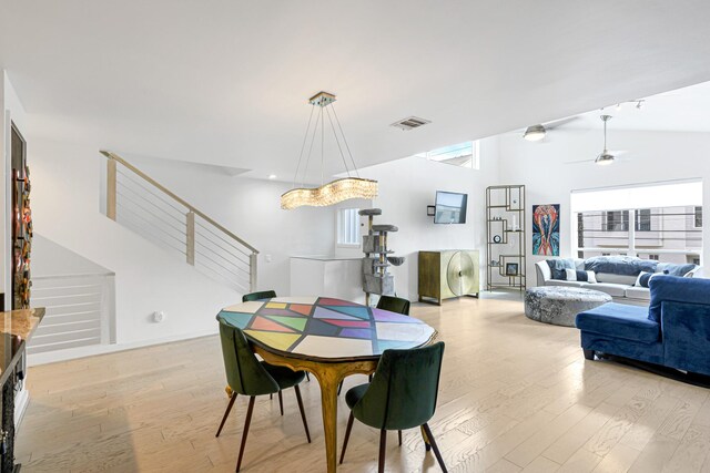 dining area with vaulted ceiling, ceiling fan, and light wood-type flooring