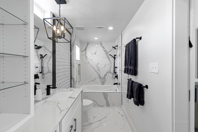 full bathroom featuring an inviting chandelier, tiled shower / bath, vanity, and toilet