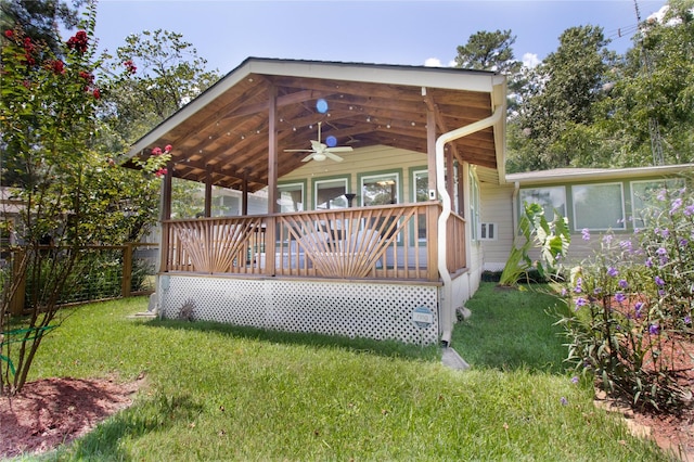 wooden terrace featuring a yard and ceiling fan