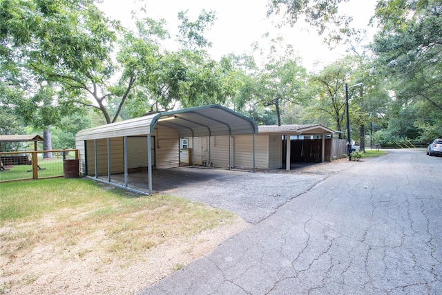 view of outdoor structure featuring a carport and a lawn