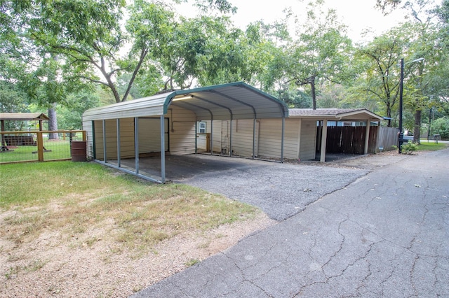 view of outdoor structure featuring a carport and a lawn