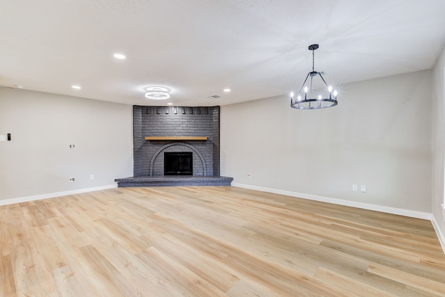 unfurnished living room featuring light wood-type flooring and a fireplace