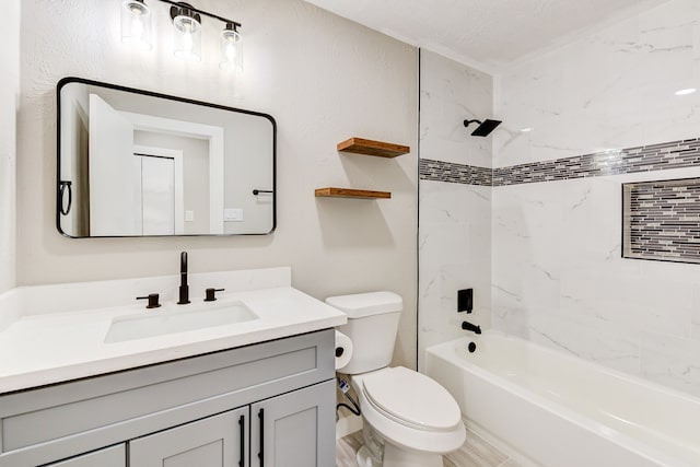 full bathroom with tiled shower / bath, vanity, and toilet