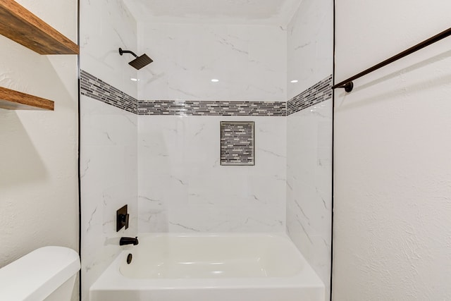 bathroom featuring tiled shower / bath and toilet