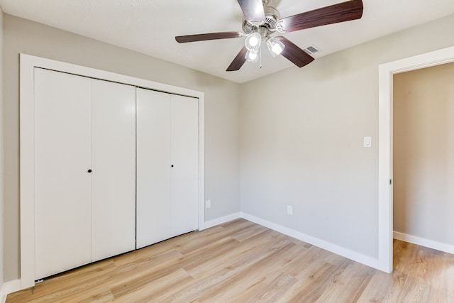 unfurnished bedroom with light hardwood / wood-style floors, a closet, and ceiling fan