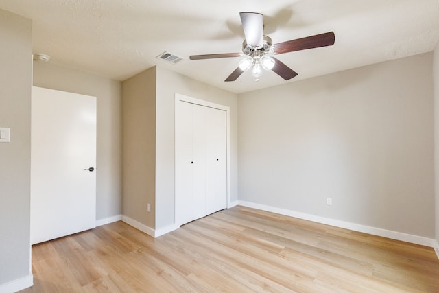 unfurnished bedroom featuring ceiling fan, a closet, and light hardwood / wood-style flooring