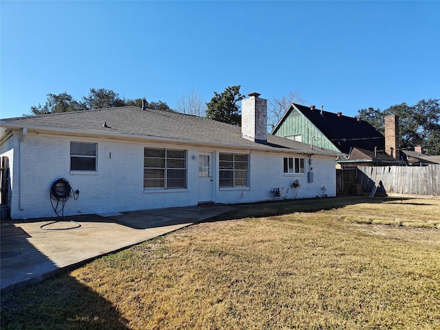 rear view of house with a patio and a yard