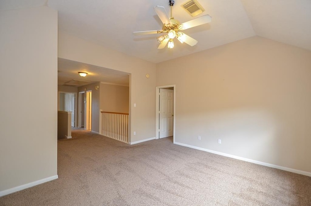 carpeted spare room featuring baseboards, visible vents, vaulted ceiling, and a ceiling fan