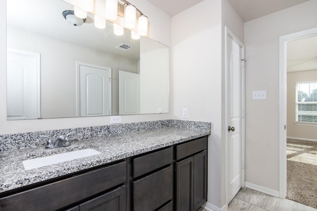 bathroom featuring visible vents, vanity, and baseboards