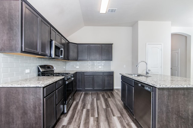 kitchen featuring sink, dark hardwood / wood-style flooring, stainless steel appliances, dark brown cabinets, and a center island with sink