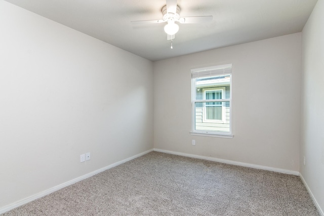 carpeted empty room featuring a ceiling fan and baseboards