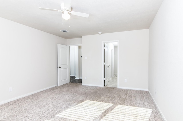 unfurnished bedroom with carpet floors, visible vents, a ceiling fan, connected bathroom, and baseboards