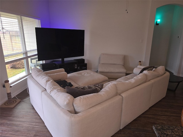 living area featuring arched walkways and wood finished floors