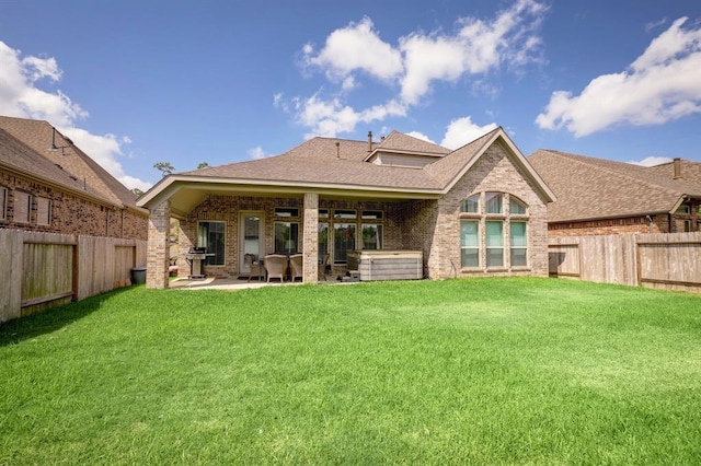 rear view of property featuring a lawn and a patio area