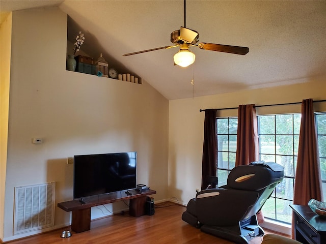 interior space featuring vaulted ceiling, wood finished floors, visible vents, and a healthy amount of sunlight