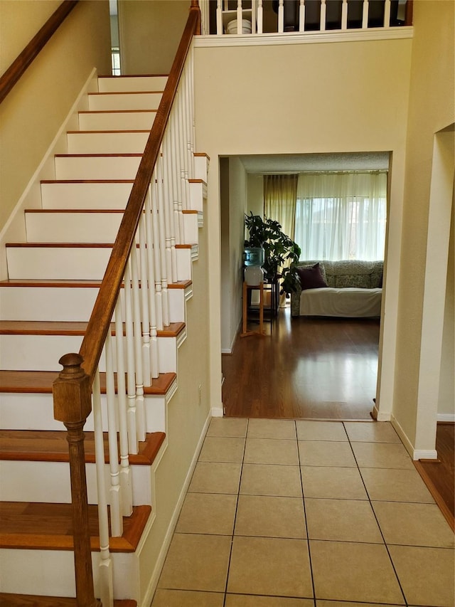 staircase with tile patterned flooring and baseboards