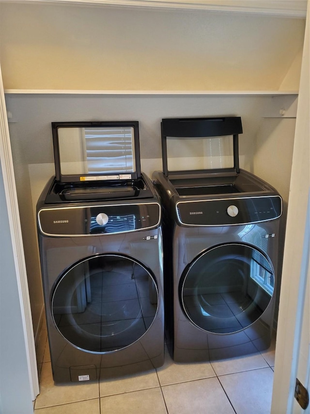 washroom featuring laundry area, washing machine and dryer, and tile patterned flooring