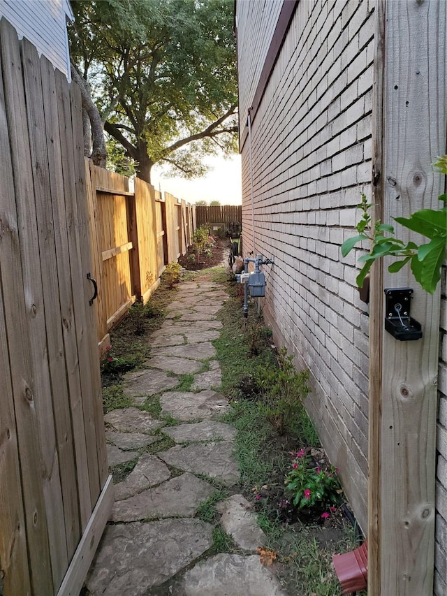 view of home's exterior with brick siding and fence