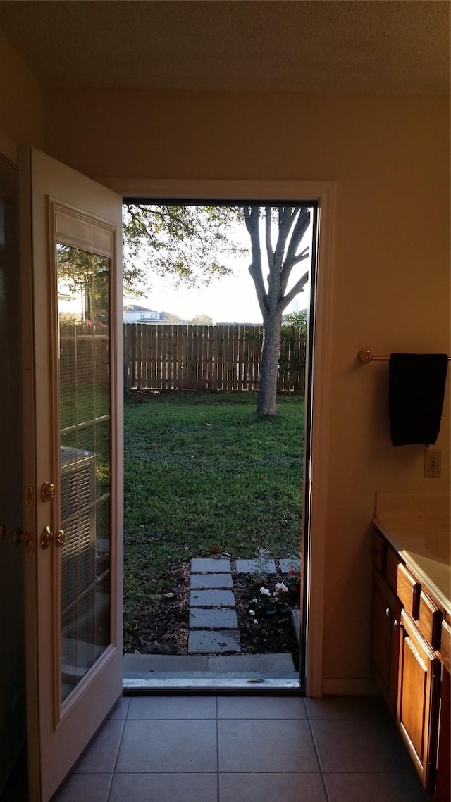 doorway to outside with light tile patterned floors