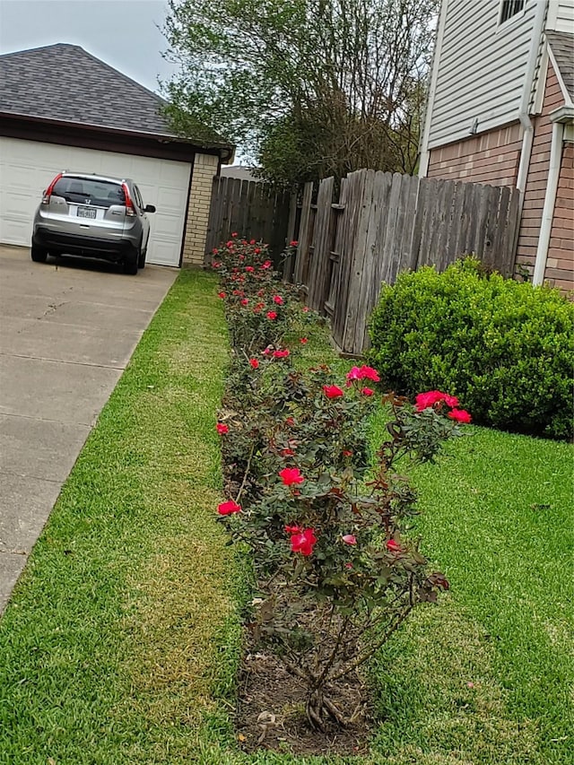 view of yard with driveway and fence