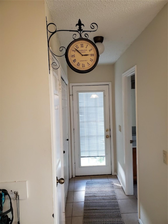 doorway featuring light tile patterned floors and a textured ceiling