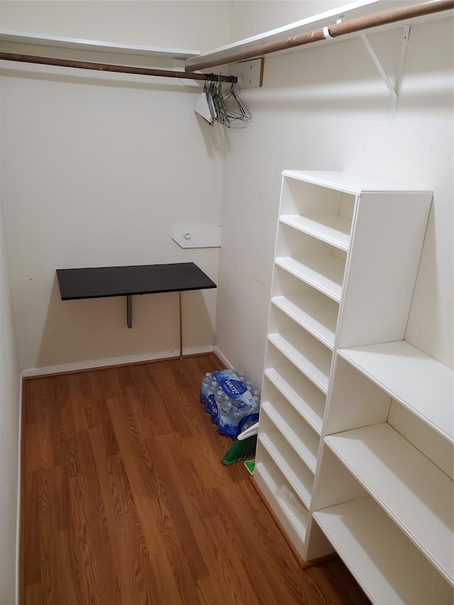 walk in closet with wood finished floors