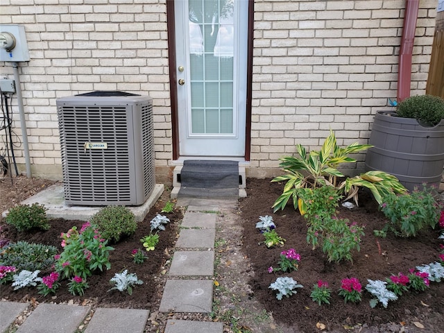 doorway to property featuring central air condition unit and brick siding