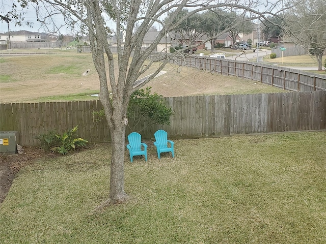 view of yard with a fenced backyard and a residential view