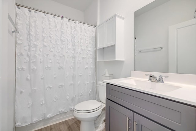 full bath with toilet, shower / bath combo with shower curtain, wood finished floors, and vanity