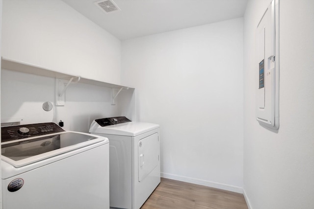 laundry room featuring laundry area, baseboards, visible vents, washing machine and clothes dryer, and light wood-style floors