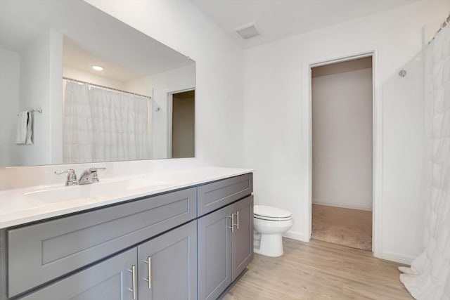 full bath with toilet, vanity, wood finished floors, a shower with curtain, and baseboards