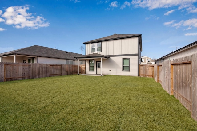 back of property featuring board and batten siding, a fenced backyard, and a yard