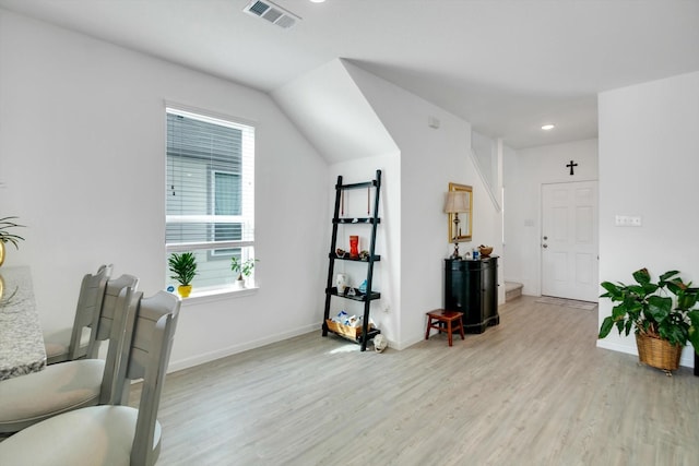 living area featuring light wood-style flooring, visible vents, and baseboards