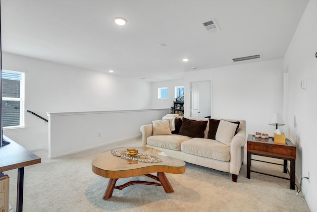 carpeted living room featuring baseboards, visible vents, and recessed lighting