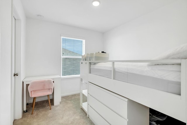 bedroom featuring light carpet and baseboards