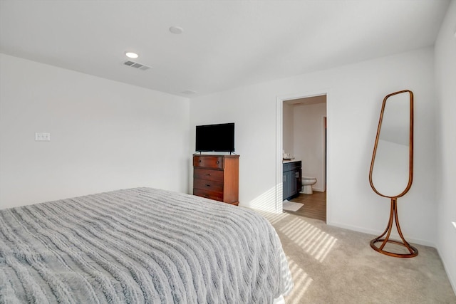 bedroom featuring carpet, visible vents, baseboards, and ensuite bathroom