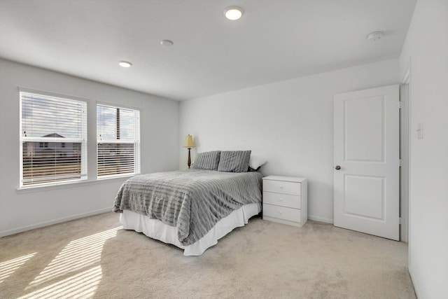 bedroom with light colored carpet and baseboards