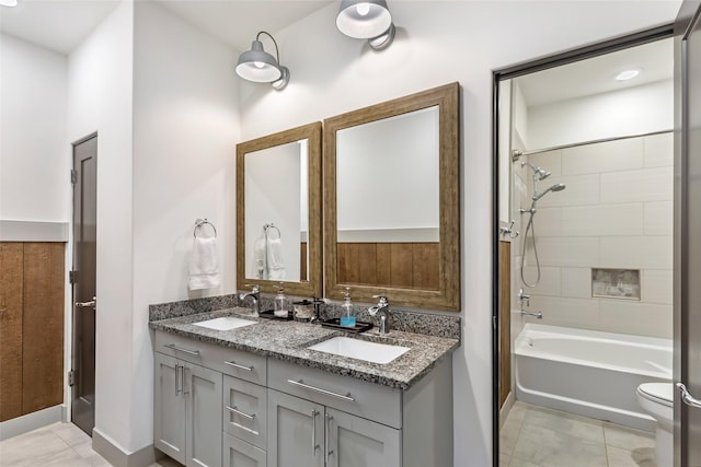 full bathroom with tiled shower / bath combo, vanity, tile patterned floors, and toilet