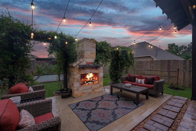 patio terrace at dusk featuring an outdoor living space with a fireplace