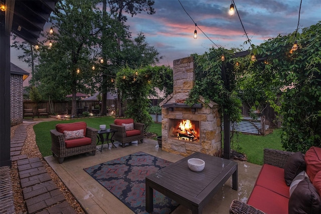 patio terrace at dusk with an outdoor living space with a fireplace