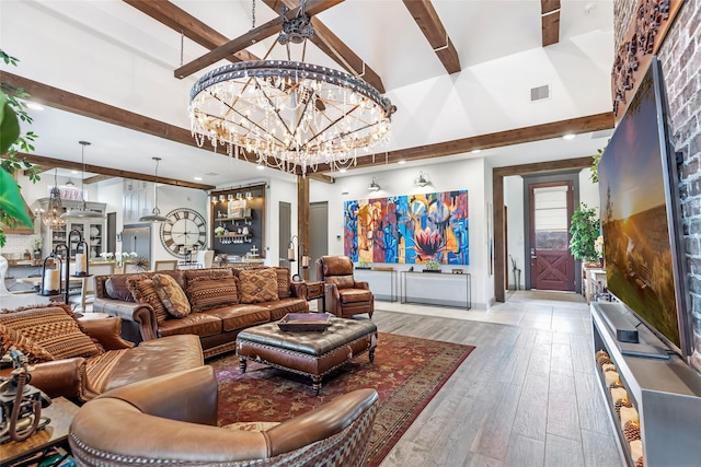 living room with a towering ceiling, a notable chandelier, beam ceiling, and light wood-type flooring