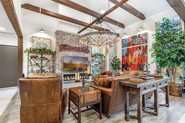 living room with lofted ceiling with beams, a fireplace, light hardwood / wood-style floors, and a notable chandelier