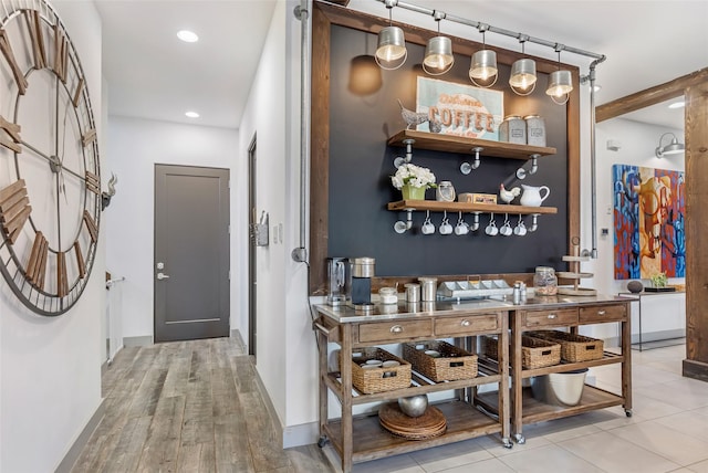 bar featuring hanging light fixtures and light wood-type flooring