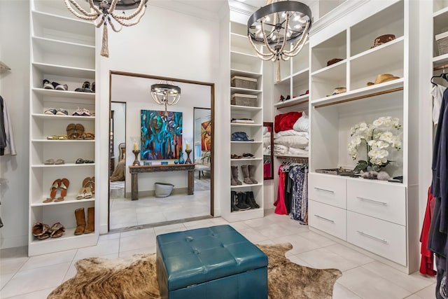 spacious closet with light tile patterned floors and a chandelier