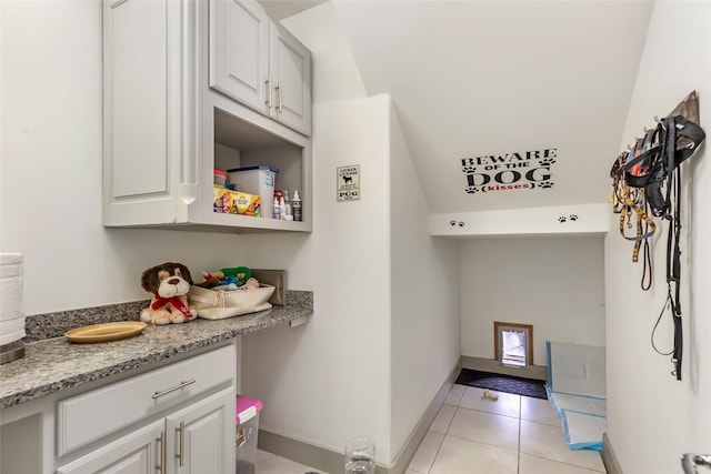 laundry area with light tile patterned floors