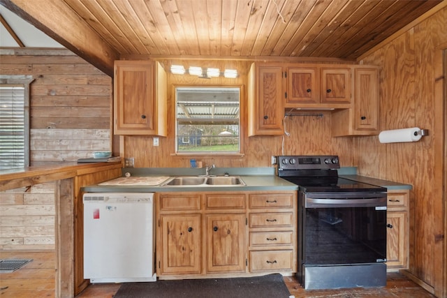 kitchen with white dishwasher, sink, wooden walls, and stainless steel electric range oven