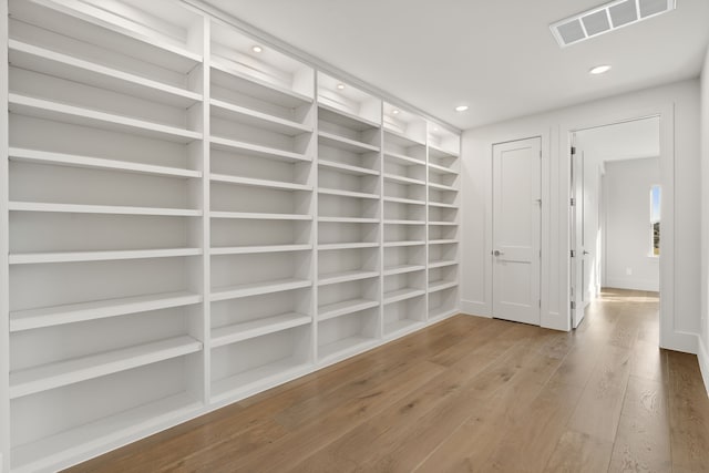 spare room featuring recessed lighting, visible vents, baseboards, and hardwood / wood-style flooring