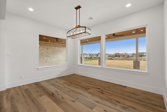 unfurnished dining area featuring baseboards, visible vents, wood finished floors, and recessed lighting